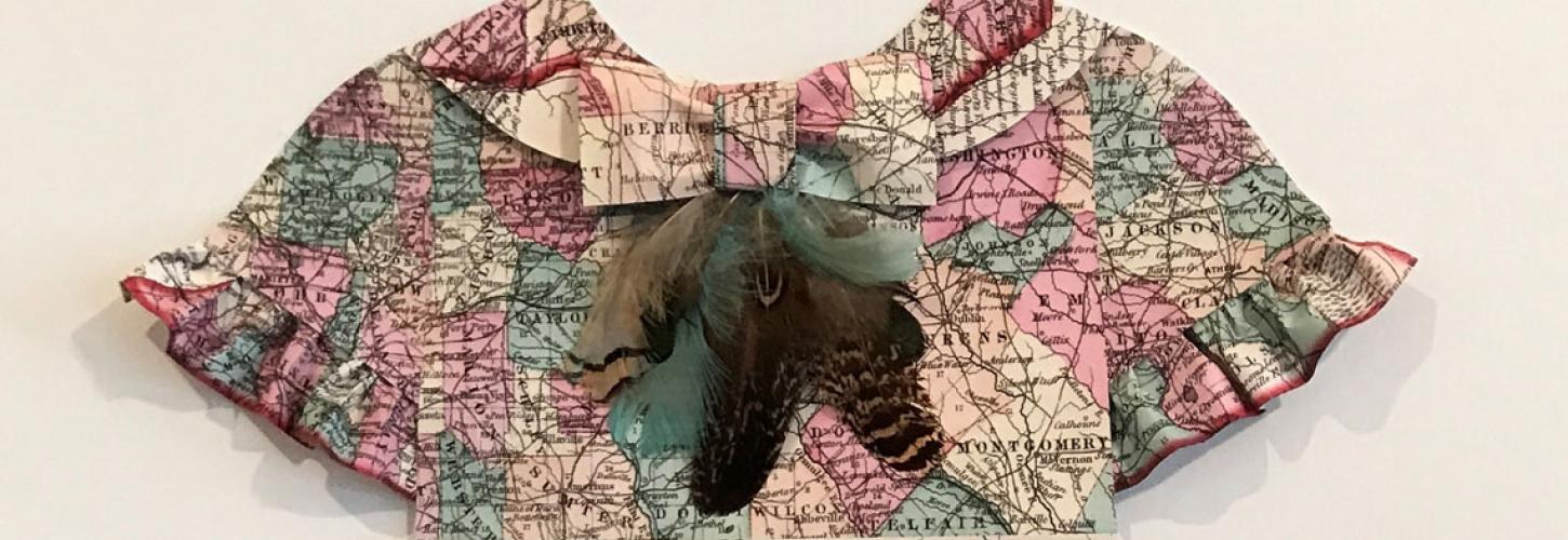 Art exhibit of maps folded into children's clothing