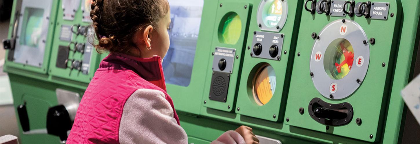 little girl playing on fake plane