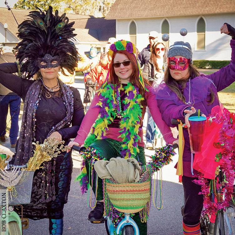 Three women dress in Mardi Gras colors to celebrate Party Gras in Darien, Georgia
