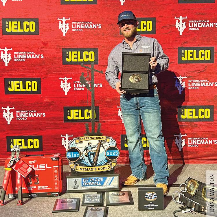 apprentice lineman poses with award