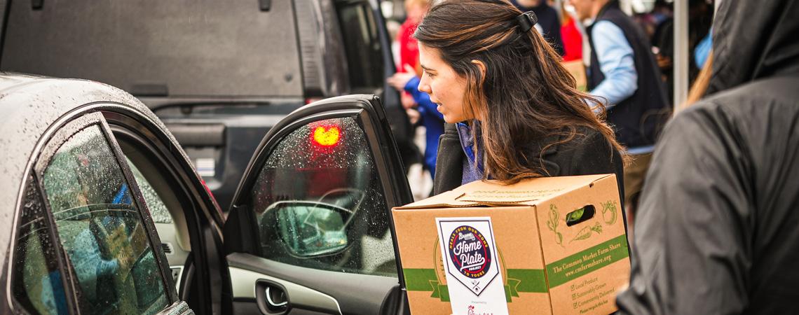 A volunteer delivers a box of food to a family in need