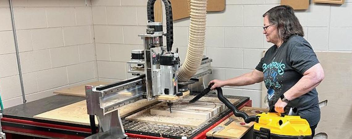 A member of the FABLab uses a CNC router to create a custom wood project