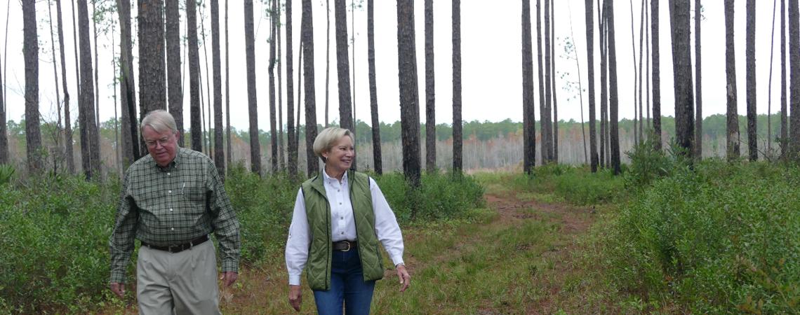 Claire Shelton Lee walks through her family's tree farm with cousin Richard Shelton